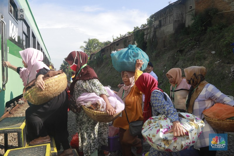 Sekelompok pedagang membawa barang daganganya untuk ditaiki ke kereta gerbong khusus petani dan pedagang di Kawasan Stasiun Cikeusal, Banten, Selasa, (2/12/2025). (CNBC Indonesia/Muhammad Sabki)