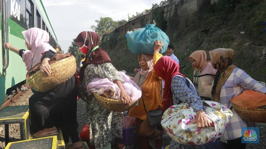 Sekelompok pedagang membawa barang daganganya untuk ditaiki ke kereta gerbong khusus petani dan pedagang di Kawasan Stasiun Cikeusal, Banten, Selasa, (2/12/2025). (CNBC Indonesia/Muhammad Sabki)