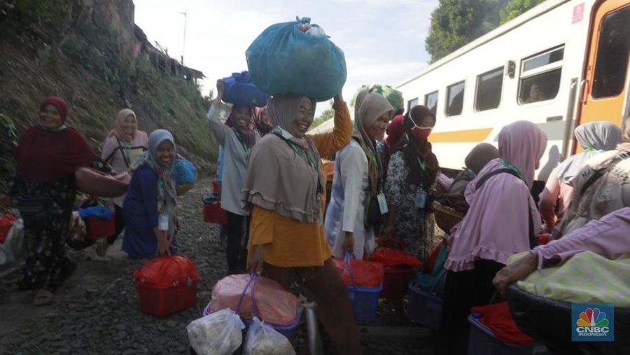Sekelompok pedagang membawa barang daganganya untuk ditaiki ke kereta gerbong khusus petani dan pedagang di Kawasan Stasiun Cikeusal, Banten, Selasa, (2/12/2025). (CNBC Indonesia/Muhammad Sabki)