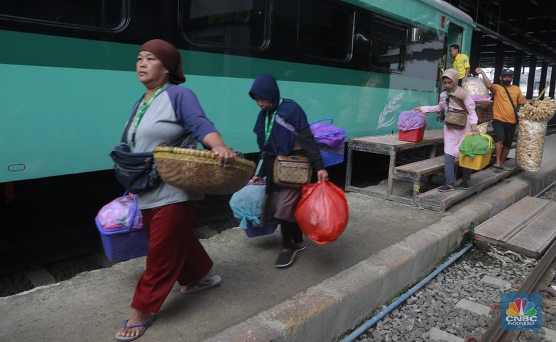 Sekelompok pedagang membawa barang daganganya untuk ditaiki ke kereta gerbong khusus petani dan pedagang di Kawasan Stasiun Cikeusal, Banten, Selasa, (2/12/2025). (CNBC Indonesia/Muhammad Sabki)