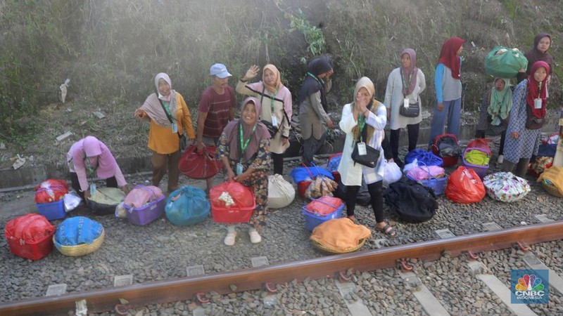 Sekelompok pedagang membawa barang daganganya untuk ditaiki ke kereta gerbong khusus petani dan pedagang di Kawasan Stasiun Cikeusal, Banten, Selasa, (2/12/2025). (CNBC Indonesia/Muhammad Sabki)