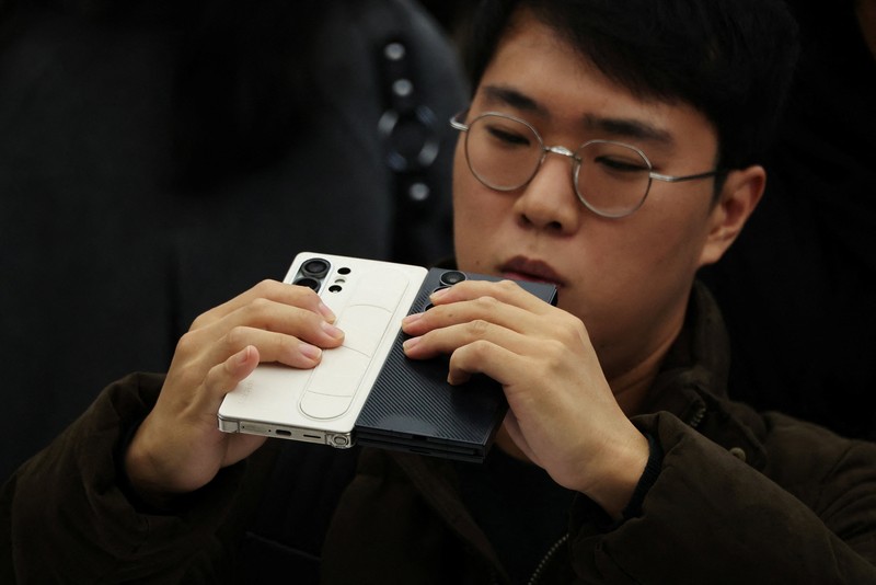Seorang model berpose untuk foto dengan Galaxy Z TriFold selama acara di tokonya di Seoul, Korea Selatan, 2 Desember 2025. (REUTERS/Kim Hong-Ji)