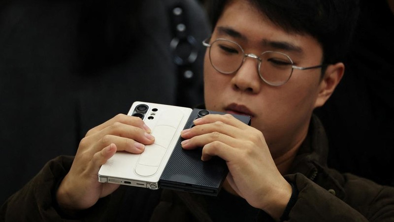 Seorang model berpose untuk foto dengan Galaxy Z TriFold selama acara di tokonya di Seoul, Korea Selatan, 2 Desember 2025. (REUTERS/Kim Hong-Ji)