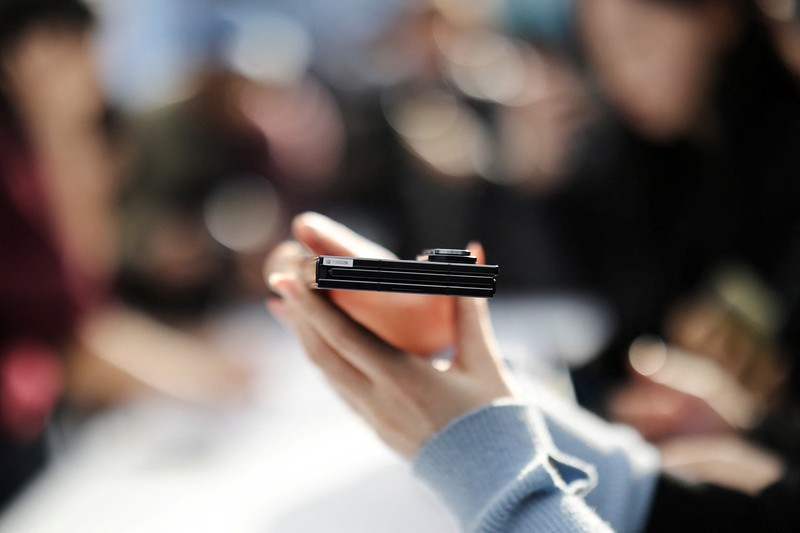 Seorang model berpose untuk foto dengan Galaxy Z TriFold selama acara di tokonya di Seoul, Korea Selatan, 2 Desember 2025. (REUTERS/Kim Hong-Ji)