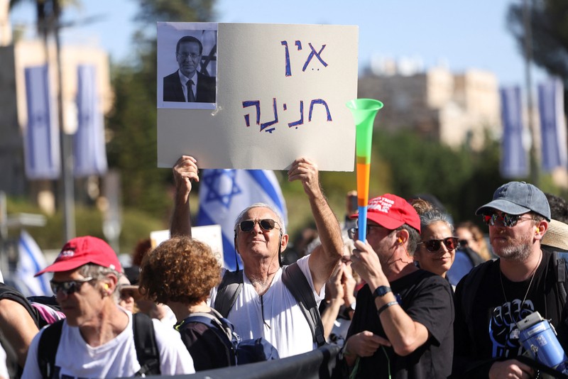 Warga Israel berunjuk rasa setelah Perdana Menteri Benjamin Netanyahu meminta grasi kepada Presiden Isaac Herzog dalam persidangan pidananya, di luar kediaman Presiden di Yerusalem, 2 Desember 2025. (REUTERS/Ronen Zvulun)