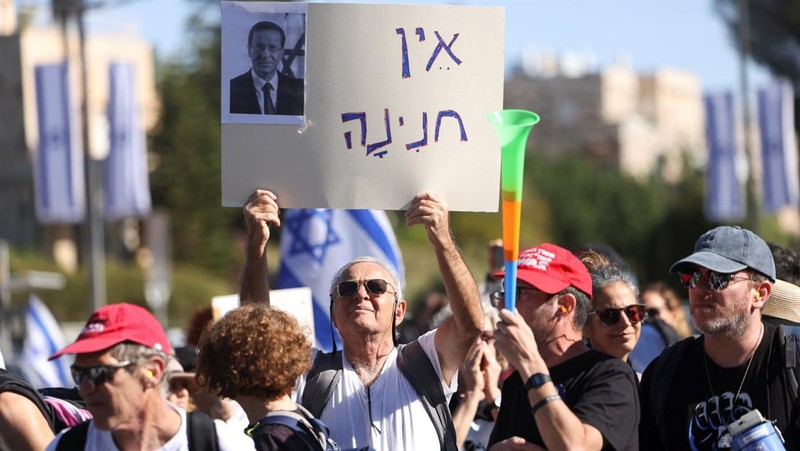 Warga Israel berunjuk rasa setelah Perdana Menteri Benjamin Netanyahu meminta grasi kepada Presiden Isaac Herzog dalam persidangan pidananya, di luar kediaman Presiden di Yerusalem, 2 Desember 2025. (REUTERS/Ronen Zvulun)