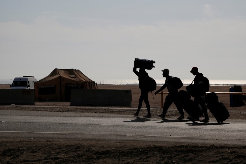 Polisi Peru berdiri di dekat Kompleks Perbatasan Chacalluta untuk memblokir migran Venezuela yang ingin meninggalkan Chili di tengah retorika anti-imigran dari kandidat presiden Chili sayap kanan Jose Antonio Kast, sementara Presiden Peru Jose Jeri berencana untuk mengumumkan keadaan darurat dan mengerahkan pasukan di perlintasan perbatasan, seperti yang terlihat dari Arica, Chili, 1 Desember 2025. (REUTERS/ Alexander Infante)