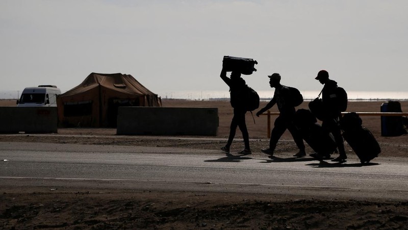 Polisi Peru berdiri di dekat Kompleks Perbatasan Chacalluta untuk memblokir migran Venezuela yang ingin meninggalkan Chili di tengah retorika anti-imigran dari kandidat presiden Chili sayap kanan Jose Antonio Kast, sementara Presiden Peru Jose Jeri berencana untuk mengumumkan keadaan darurat dan mengerahkan pasukan di perlintasan perbatasan, seperti yang terlihat dari Arica, Chili, 1 Desember 2025. (REUTERS/ Alexander Infante)