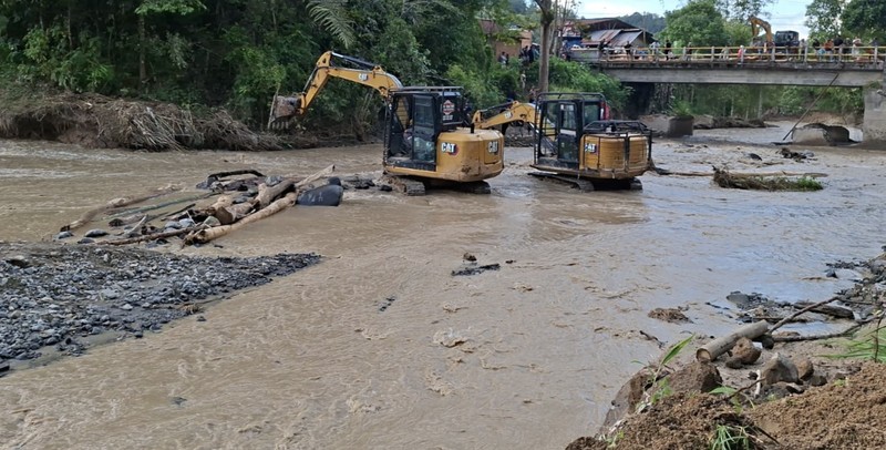Perbaikan darurat infrastruktur jembatan yang putus diterjang banjir di Kabupaten Agam, Rabu (3/12). Perbaikan darurat dilakukan dengan balok pohon kelapa sehingga akses jalan dapat dilalui paling tidak dengan kendaraan roda dua. (Dok. BNPB)