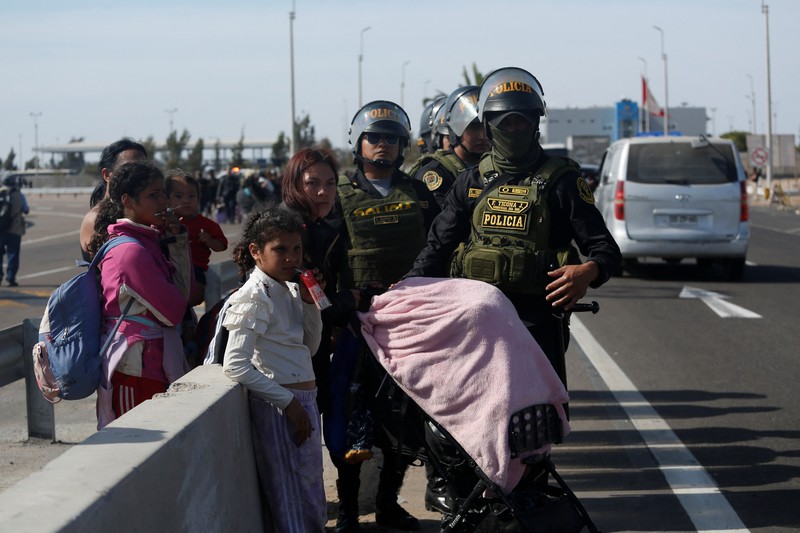 Polisi Peru berdiri di dekat Kompleks Perbatasan Chacalluta untuk memblokir migran Venezuela yang ingin meninggalkan Chili di tengah retorika anti-imigran dari kandidat presiden Chili sayap kanan Jose Antonio Kast, sementara Presiden Peru Jose Jeri berencana untuk mengumumkan keadaan darurat dan mengerahkan pasukan di perlintasan perbatasan, seperti yang terlihat dari Arica, Chili, 1 Desember 2025. (REUTERS/ Alexander Infante)
