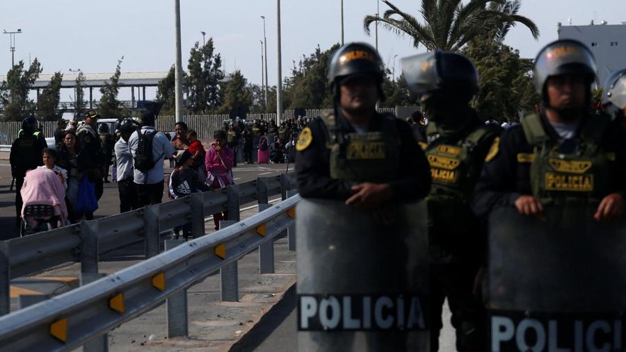 Polisi Peru berdiri di dekat Kompleks Perbatasan Chacalluta untuk memblokir migran Venezuela yang ingin meninggalkan Chili di tengah retorika anti-imigran dari kandidat presiden Chili sayap kanan Jose Antonio Kast, sementara Presiden Peru Jose Jeri berencana untuk mengumumkan keadaan darurat dan mengerahkan pasukan di perlintasan perbatasan, seperti yang terlihat dari Arica, Chili, 1 Desember 2025. (REUTERS/ Alexander Infante)