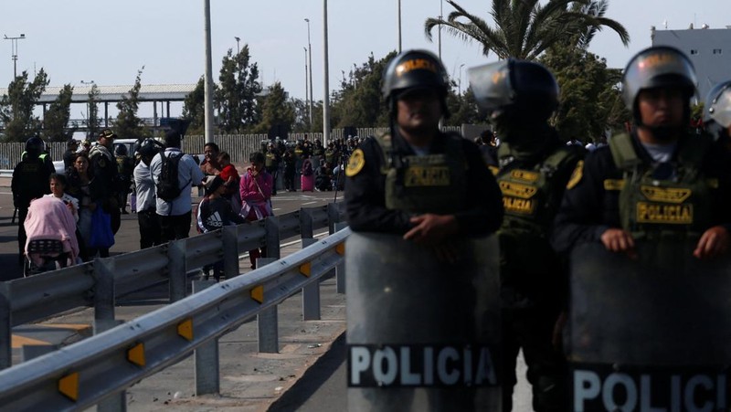 Polisi Peru berdiri di dekat Kompleks Perbatasan Chacalluta untuk memblokir migran Venezuela yang ingin meninggalkan Chili di tengah retorika anti-imigran dari kandidat presiden Chili sayap kanan Jose Antonio Kast, sementara Presiden Peru Jose Jeri berencana untuk mengumumkan keadaan darurat dan mengerahkan pasukan di perlintasan perbatasan, seperti yang terlihat dari Arica, Chili, 1 Desember 2025. (REUTERS/ Alexander Infante)