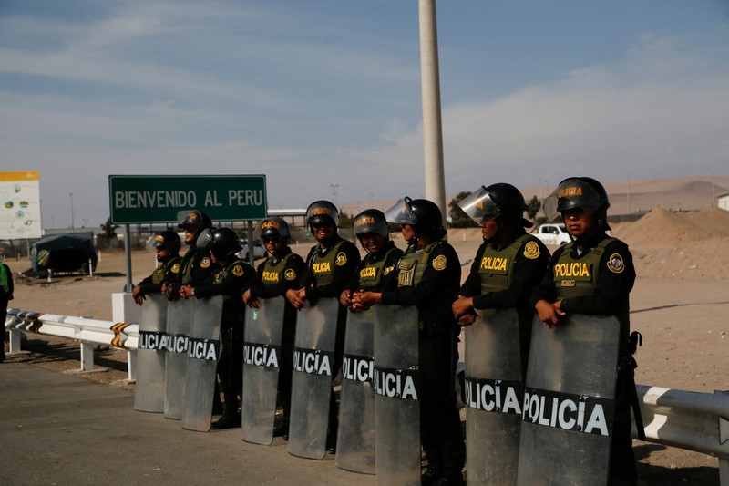 Polisi Peru berdiri di dekat Kompleks Perbatasan Chacalluta untuk memblokir migran Venezuela yang ingin meninggalkan Chili di tengah retorika anti-imigran dari kandidat presiden Chili sayap kanan Jose Antonio Kast, sementara Presiden Peru Jose Jeri berencana untuk mengumumkan keadaan darurat dan mengerahkan pasukan di perlintasan perbatasan, seperti yang terlihat dari Arica, Chili, 1 Desember 2025. (REUTERS/ Alexander Infante)