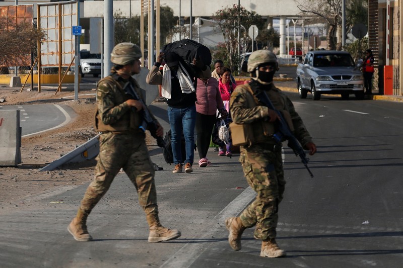 Polisi Peru berdiri di dekat Kompleks Perbatasan Chacalluta untuk memblokir migran Venezuela yang ingin meninggalkan Chili di tengah retorika anti-imigran dari kandidat presiden Chili sayap kanan Jose Antonio Kast, sementara Presiden Peru Jose Jeri berencana untuk mengumumkan keadaan darurat dan mengerahkan pasukan di perlintasan perbatasan, seperti yang terlihat dari Arica, Chili, 1 Desember 2025. (REUTERS/ Alexander Infante)