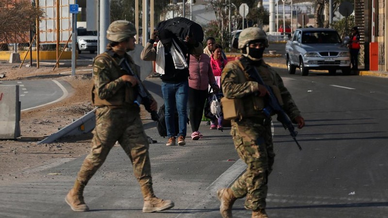 Polisi Peru berdiri di dekat Kompleks Perbatasan Chacalluta untuk memblokir migran Venezuela yang ingin meninggalkan Chili di tengah retorika anti-imigran dari kandidat presiden Chili sayap kanan Jose Antonio Kast, sementara Presiden Peru Jose Jeri berencana untuk mengumumkan keadaan darurat dan mengerahkan pasukan di perlintasan perbatasan, seperti yang terlihat dari Arica, Chili, 1 Desember 2025. (REUTERS/ Alexander Infante)
