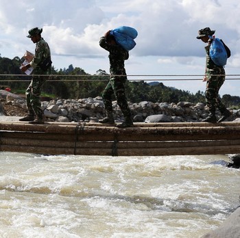 Bantuan Datang! Potret TNI - Warga Panggul Sembako Seberangi Sungai