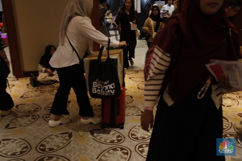 Pengunjung membawa beberapa koper saat berbelanja di Jakarta X Beauty di JCC, Senayan, Jakarta, Kamis (4/12/2025). (CNBC Indonesia/Tri Susilo)