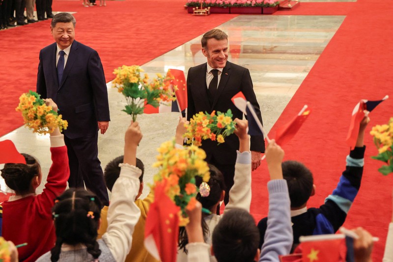 Presiden China Xi Jinping dan Presiden Prancis Macron dalam upacara penyambutan resmi di Balai Agung Rakyat di Beijing, China, Kamis (4/12/2025). (REUTERS/Sarah Meyssonnier/Pool)