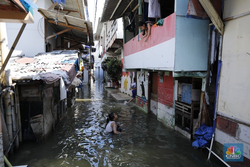 Banjir rob menggenangi wilayah Jalan Dermaga Baru, Kali Adem, Blok Empang, Muara Angke, Jakarta, Jumat (5/12/2025). Meski terendam banjir, warga memilih bertahan di rumahnya masing-masing. (CNBC Indonesia/Tri Susilo)