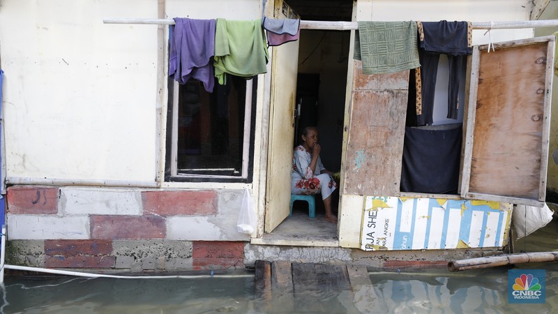 Banjir rob menggenangi wilayah Jalan Dermaga Baru, Kali Adem, Blok Empang, Muara Angke, Jakarta, Jumat (5/12/2025). Meski terendam banjir, warga memilih bertahan di rumahnya masing-masing. (CNBC Indonesia/Tri Susilo)