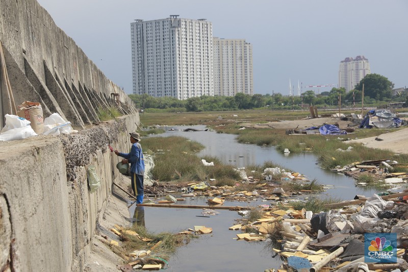 Petugas Dinas Sumber Daya Air (SDA) menambal tanggul Muara Buaru yang bocor di kawasan Muara Baru, Jakarta, Jumat, (5/12/2025). (CNBC Indonesia/Muhammad Sabki)