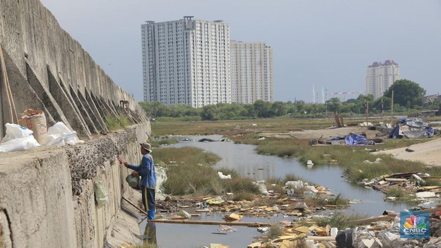 Petugas Dinas Sumber Daya Air (SDA) menambal tanggul Muara Buaru yang bocor di kawasan Muara Baru, Jakarta, Jumat, (5/12/2025). (CNBC Indonesia/Muhammad Sabki)
