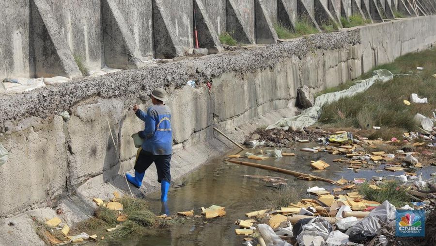 Petugas Dinas Sumber Daya Air (SDA) menambal tanggul Muara Buaru yang bocor di kawasan Muara Baru, Jakarta, Jumat, (5/12/2025). (CNBC Indonesia/Muhammad Sabki)