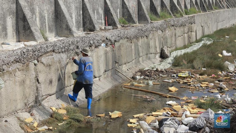 Petugas Dinas Sumber Daya Air (SDA) menambal tanggul Muara Buaru yang bocor di kawasan Muara Baru, Jakarta, Jumat, (5/12/2025). (CNBC Indonesia/Muhammad Sabki)