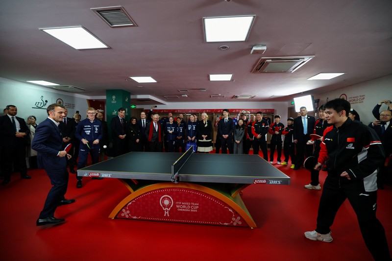 Presiden Prancis Emmanuel Macron bermain tenis meja dengan pemain tenis meja Tiongkok di Universitas Sichuan di Chengdu, provinsi Sichuan, sebagai bagian dari kunjungan tiga hari ke Tiongkok, 5 Desember 2025. (REUTERS/Sarah Meyssonnier/Pool)