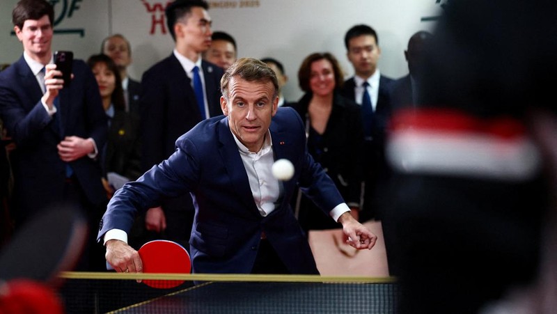 Presiden Prancis Emmanuel Macron bermain tenis meja dengan pemain tenis meja Tiongkok di Universitas Sichuan di Chengdu, provinsi Sichuan, sebagai bagian dari kunjungan tiga hari ke Tiongkok, 5 Desember 2025. (REUTERS/Sarah Meyssonnier/Pool)