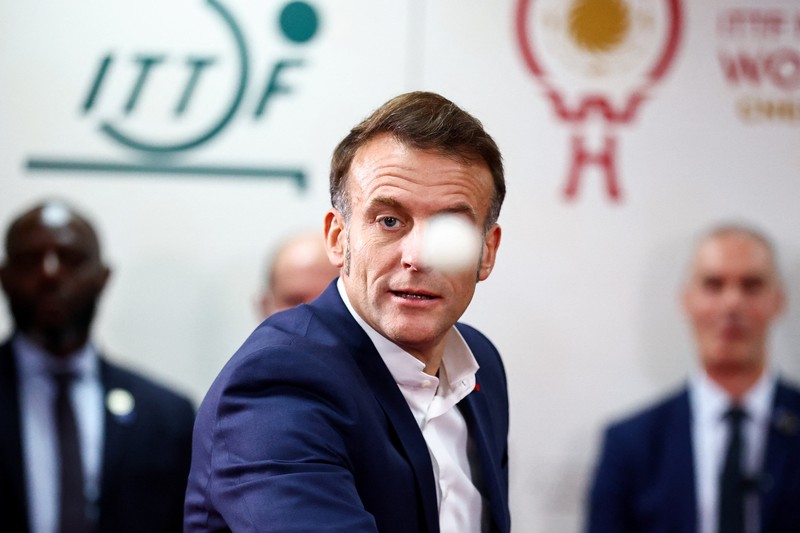 Presiden Prancis Emmanuel Macron bermain tenis meja dengan pemain tenis meja Tiongkok di Universitas Sichuan di Chengdu, provinsi Sichuan, sebagai bagian dari kunjungan tiga hari ke Tiongkok, 5 Desember 2025. (REUTERS/Sarah Meyssonnier/Pool)