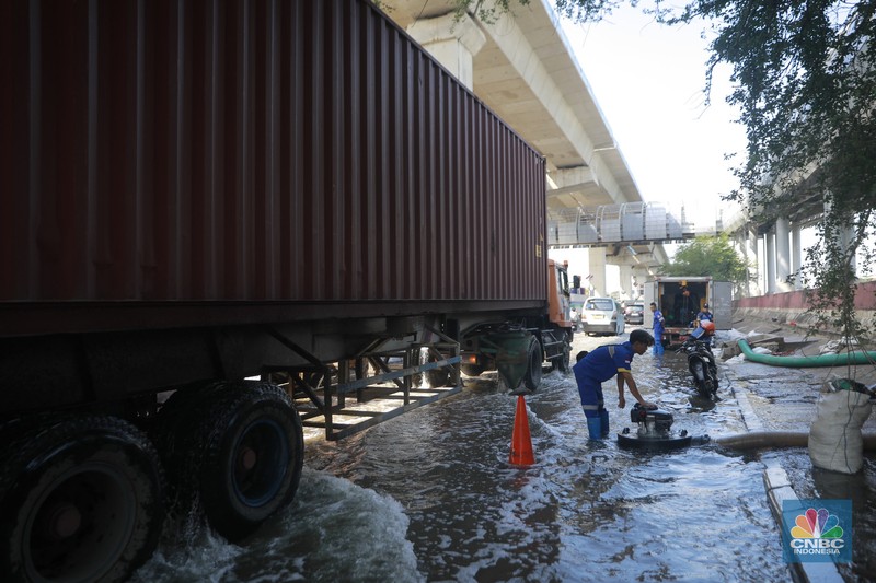 Sejumlah kendaraan roda dua dan roda empat melintasi banjir rob yang menggenangi Jalan RE Martadinata, Tanjung Priok, Jakarta Utara, Jumat (05/12/2025). (CNBC Indonesia/Muhammad Sabki)