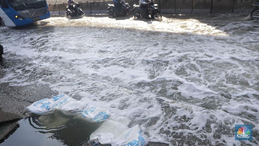 Sejumlah kendaraan roda dua dan roda empat melintasi banjir rob yang menggenangi Jalan RE Martadinata, Tanjung Priok, Jakarta Utara, Jumat (05/12/2025). (CNBC Indonesia/Muhammad Sabki)