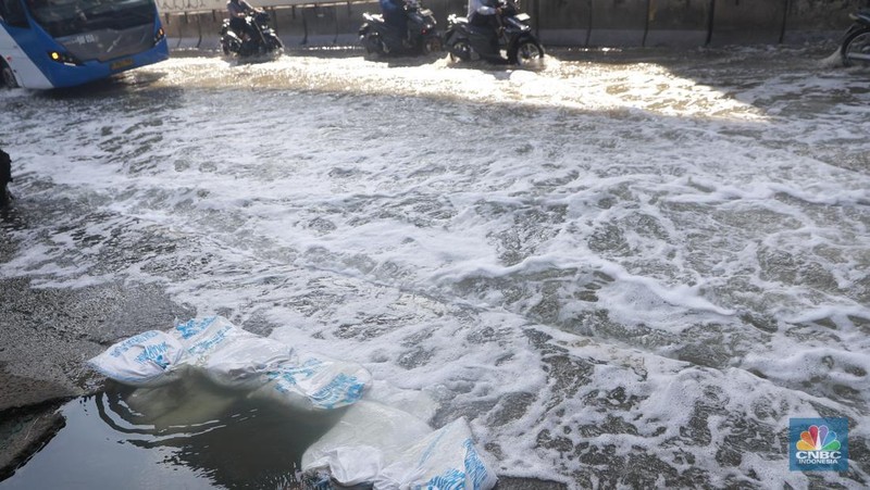 Sejumlah kendaraan roda dua dan roda empat melintasi banjir rob yang menggenangi Jalan RE Martadinata, Tanjung Priok, Jakarta Utara, Jumat (05/12/2025). (CNBC Indonesia/Muhammad Sabki)