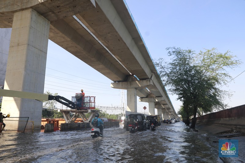 Sejumlah kendaraan roda dua dan roda empat melintasi banjir rob yang menggenangi Jalan RE Martadinata, Tanjung Priok, Jakarta Utara, Jumat (05/12/2025). (CNBC Indonesia/Muhammad Sabki)