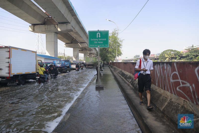 Sejumlah kendaraan roda dua dan roda empat melintasi banjir rob yang menggenangi Jalan RE Martadinata, Tanjung Priok, Jakarta Utara, Jumat (05/12/2025). (CNBC Indonesia/Muhammad Sabki)