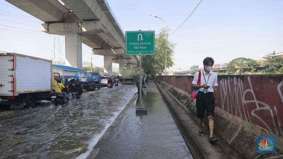Sejumlah kendaraan roda dua dan roda empat melintasi banjir rob yang menggenangi Jalan RE Martadinata, Tanjung Priok, Jakarta Utara, Jumat (05/12/2025). (CNBC Indonesia/Muhammad Sabki)