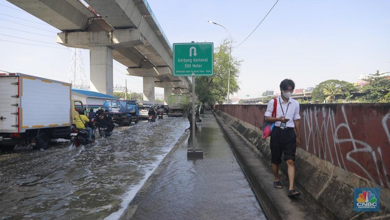Sejumlah kendaraan roda dua dan roda empat melintasi banjir rob yang menggenangi Jalan RE Martadinata, Tanjung Priok, Jakarta Utara, Jumat (05/12/2025). (CNBC Indonesia/Muhammad Sabki)