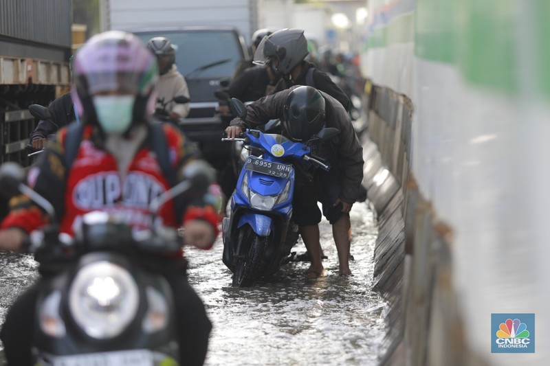 Sejumlah kendaraan roda dua dan roda empat melintasi banjir rob yang menggenangi Jalan RE Martadinata, Tanjung Priok, Jakarta Utara, Jumat (05/12/2025). (CNBC Indonesia/Muhammad Sabki)