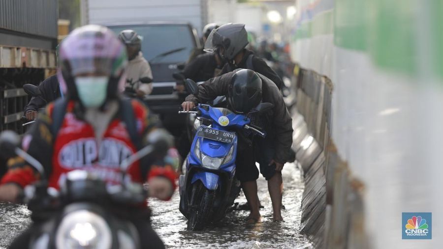 Sejumlah kendaraan roda dua dan roda empat melintasi banjir rob yang menggenangi Jalan RE Martadinata, Tanjung Priok, Jakarta Utara, Jumat (05/12/2025). (CNBC Indonesia/Muhammad Sabki)