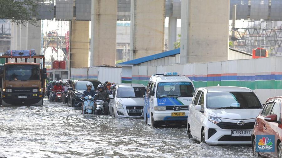 Sejumlah kendaraan roda dua dan roda empat melintasi banjir rob yang menggenangi Jalan RE Martadinata, Tanjung Priok, Jakarta Utara, Jumat (05/12/2025). (CNBC Indonesia/Muhammad Sabki)