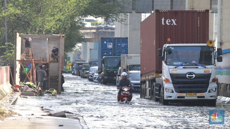 Sejumlah kendaraan roda dua dan roda empat melintasi banjir rob yang menggenangi Jalan RE Martadinata, Tanjung Priok, Jakarta Utara, Jumat (05/12/2025). (CNBC Indonesia/Muhammad Sabki)