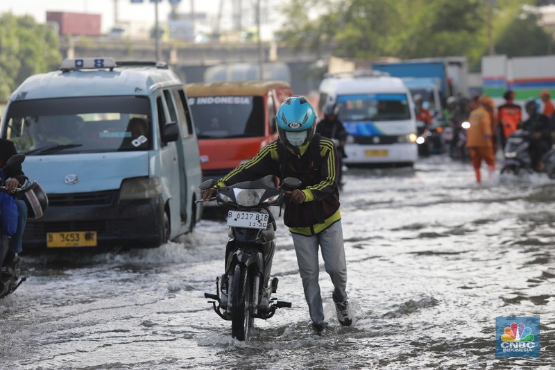 Sejumlah kendaraan roda dua dan roda empat melintasi banjir rob yang menggenangi Jalan RE Martadinata, Tanjung Priok, Jakarta Utara, Jumat (05/12/2025). (CNBC Indonesia/Muhammad Sabki)