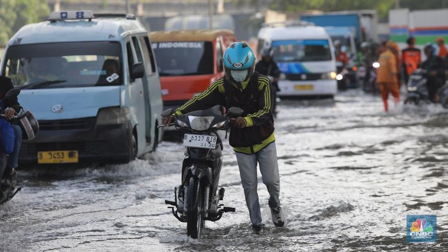 Sejumlah kendaraan roda dua dan roda empat melintasi banjir rob yang menggenangi Jalan RE Martadinata, Tanjung Priok, Jakarta Utara, Jumat (05/12/2025). (CNBC Indonesia/Muhammad Sabki)
