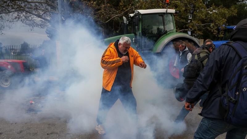 Seorang petani berdiri di depan barisan polisi anti huru hara selama protes di Thessaloniki, Yunani, 5 Desember 2025. (REUTERS/Alexandros Avramidis)