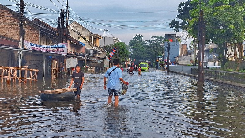 Sejumlah kendaraan roda dua dan roda empat melintasi banjir rob yang menggenangi Jalan RE Martadinata, Tanjung Priok, Jakarta Utara, Jumat (05/12/2025). (CNBC Indonesia/Muhammad Sabki)