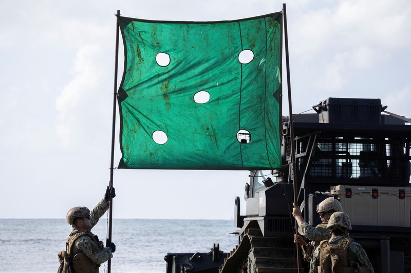 Sebuah Kapal Pengintai Amfibi Ringan (LARC) Angkatan Laut AS meluncur dari kapal pendarat utilitas Angkatan Laut AS (LCU-1662) saat pergerakan militer berlangsung di pantai di Arroyo, Puerto Riko, 5 Desember 2025. (REUTERS/Ricardo Arduengo)