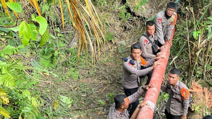 Tampak Personel Polri bahu membahu mengangkut tiang listrik di tengah medan yang sulit menuju lokasi terdampak banjir dan tanah longsor di wilayah Sicincin, Padang Pariaman, Sumatra Barat. Pendistribusian material secara manual ini dilakukan guna mempercepat proses pemulihan kelistrikan saat akses ke lokasi tersebut masih terputus dan tidak dapat dilalui dengan kendaraan. (Dok. PLN)