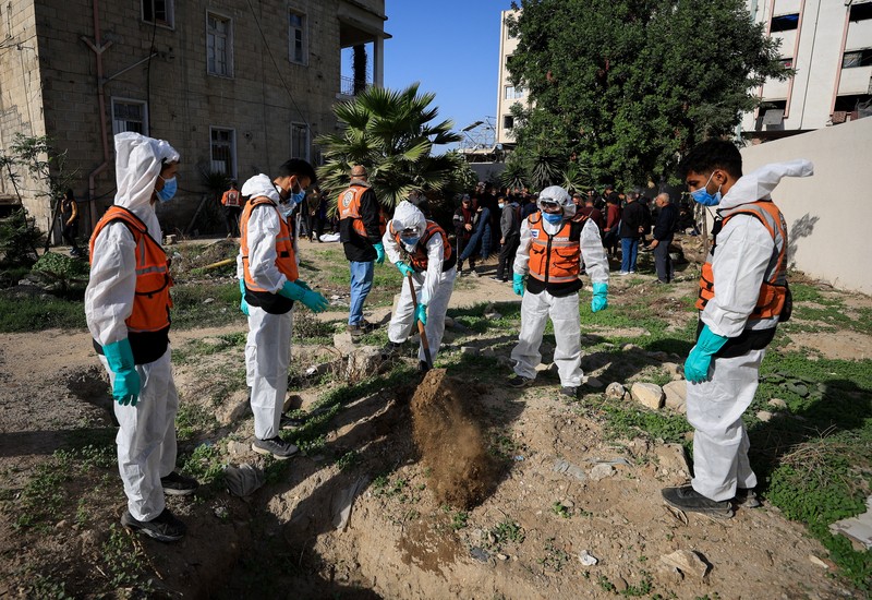 nggota Pertahanan Sipil Palestina menggali kembali jenazah orang-orang yang tewas selama perang untuk dimakamkan kembali, di Rumah Sakit Al-Ahli di Kota Gaza, Minggu (7/12/2025). (REUTERS/Dawoud Abu Alkas)