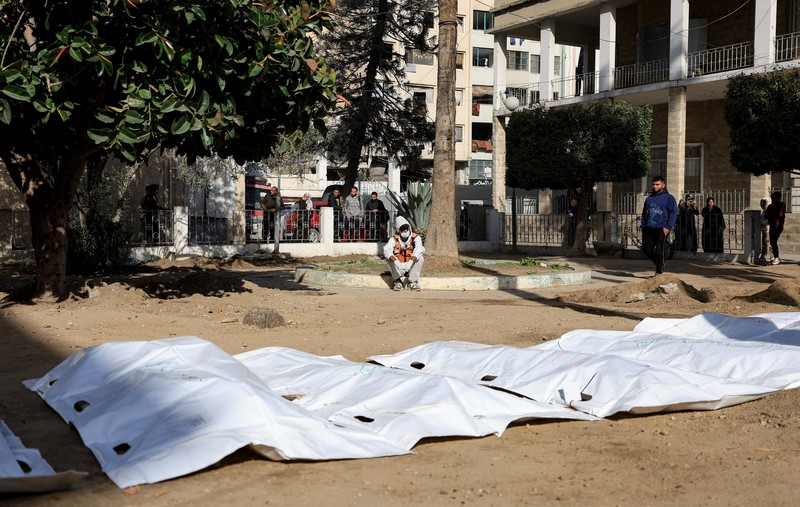 nggota Pertahanan Sipil Palestina menggali kembali jenazah orang-orang yang tewas selama perang untuk dimakamkan kembali, di Rumah Sakit Al-Ahli di Kota Gaza, Minggu (7/12/2025). (REUTERS/Dawoud Abu Alkas)